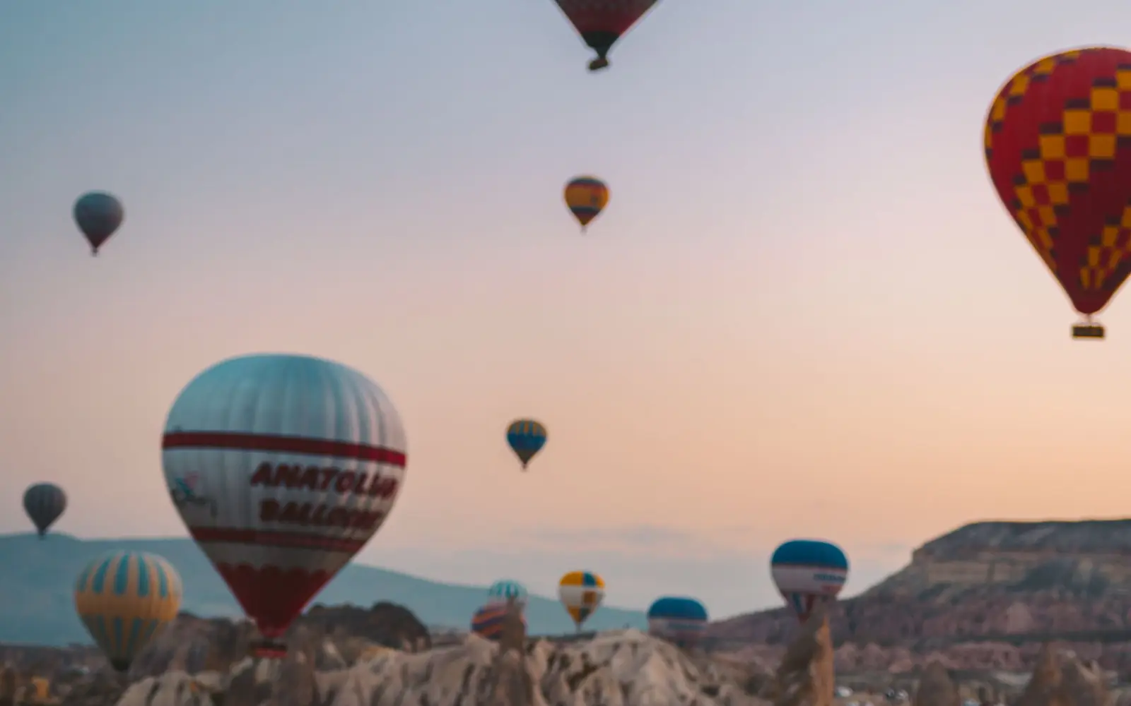 Kapadokya vadisi üzerinde gün doğumunda uçan sıcak hava balonları